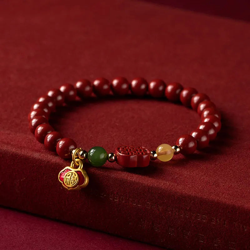 Emperor Sandstone Happy Eyebrow Bracelet with cinnabar accents and fu character charm on wrist.