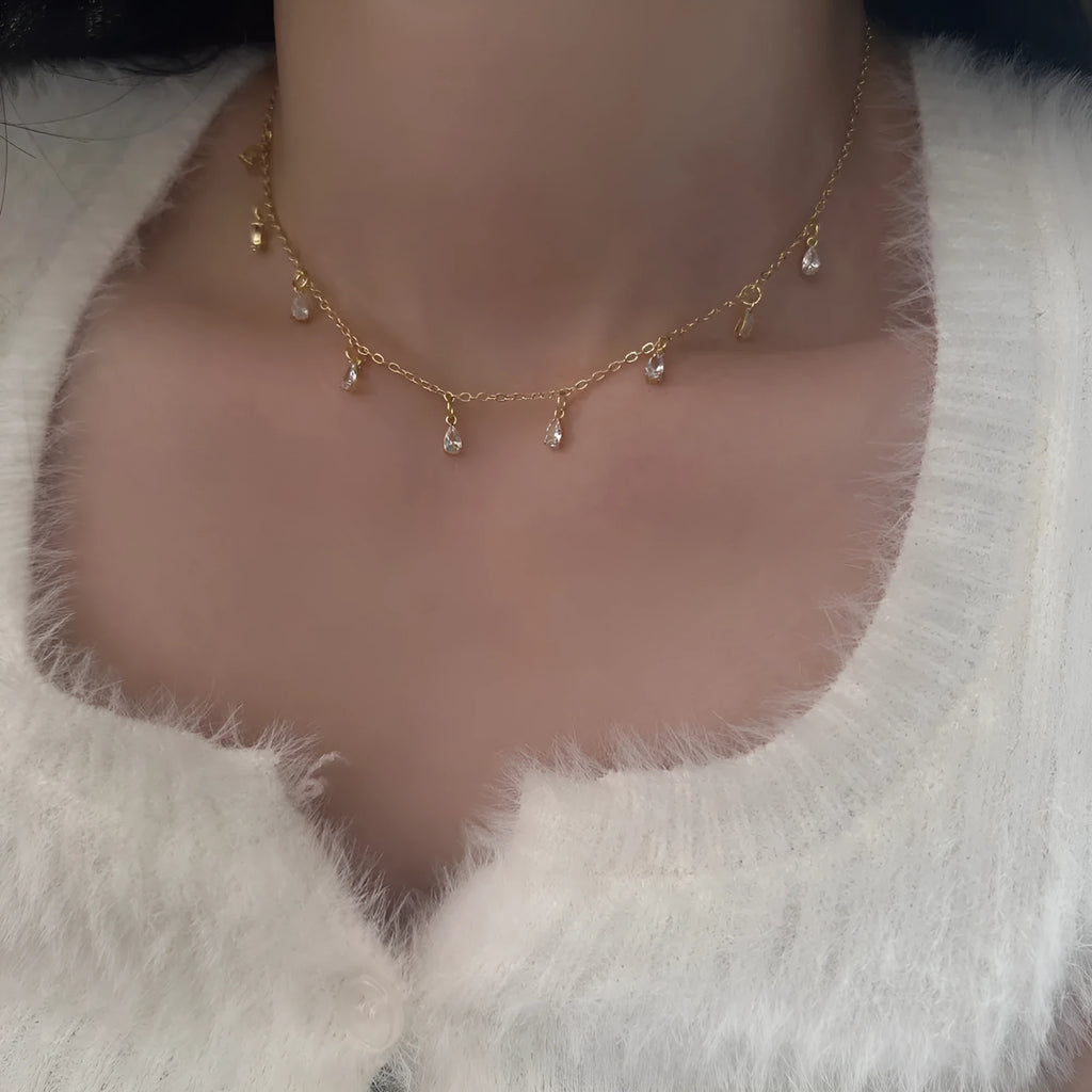 A women's zircon jewellery set showing a geometric meteor shower necklace, matching earrings, and an anklet on a white background.