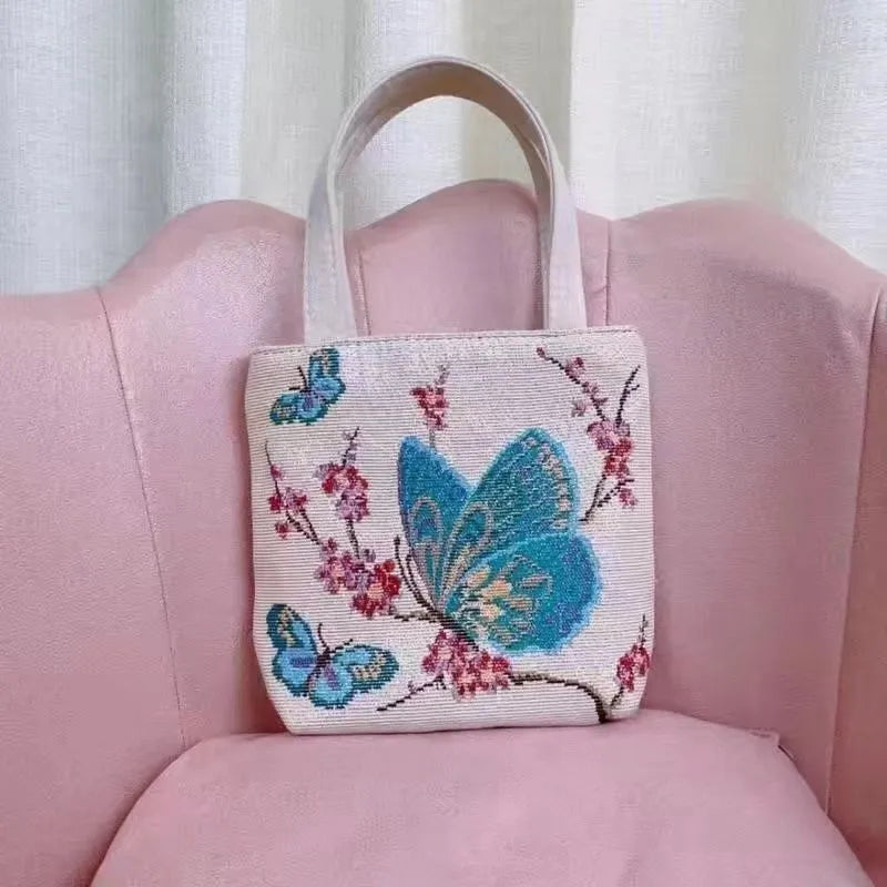 Double-sided gold wire embroidered canvas handheld bag in a floral design with polyester lining.