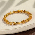Handmade women's bracelet with tiger eye gemstone beads carved into small fish designs
