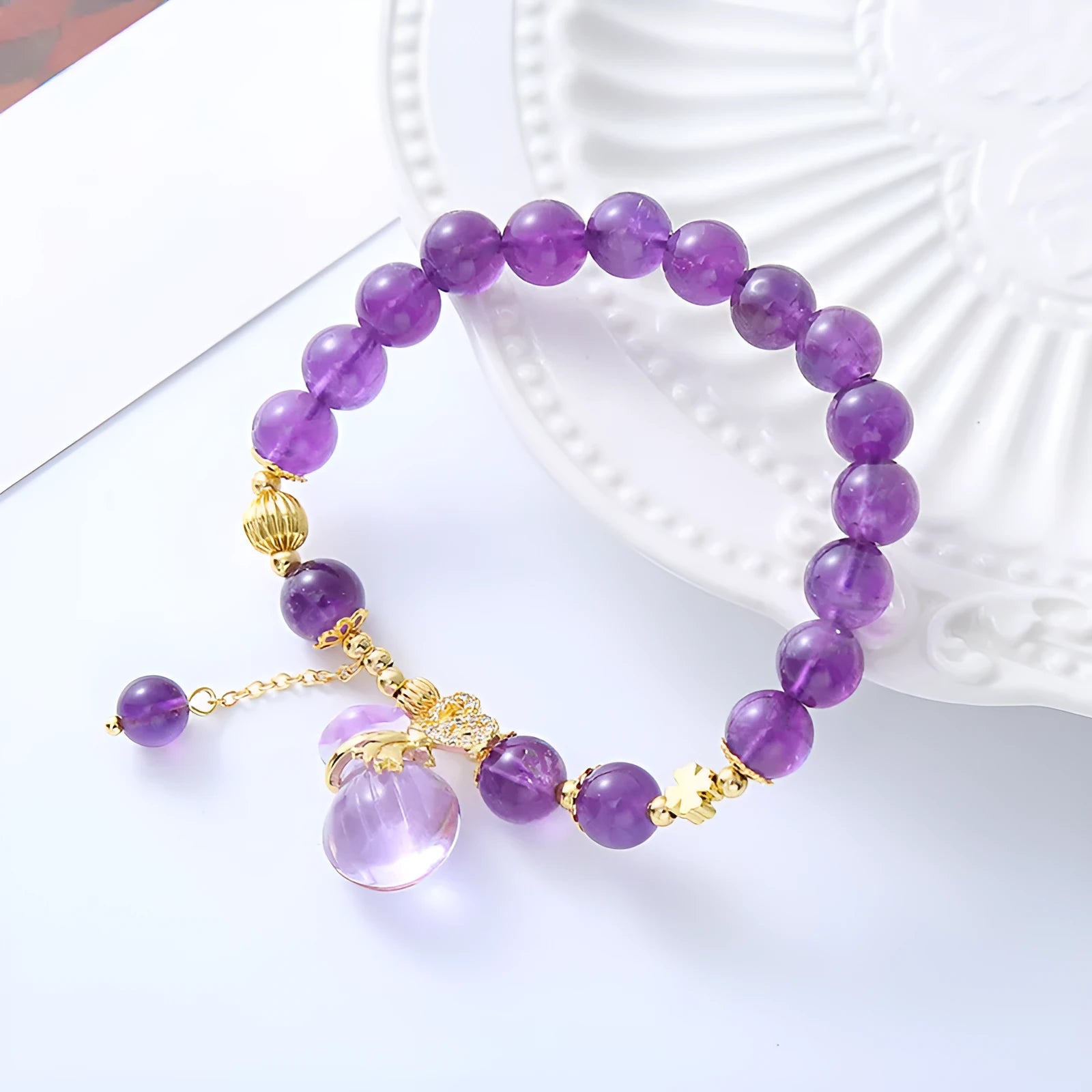 Purple crystal bracelet with ethnic money bag pendant and peace buckle closure on wrist