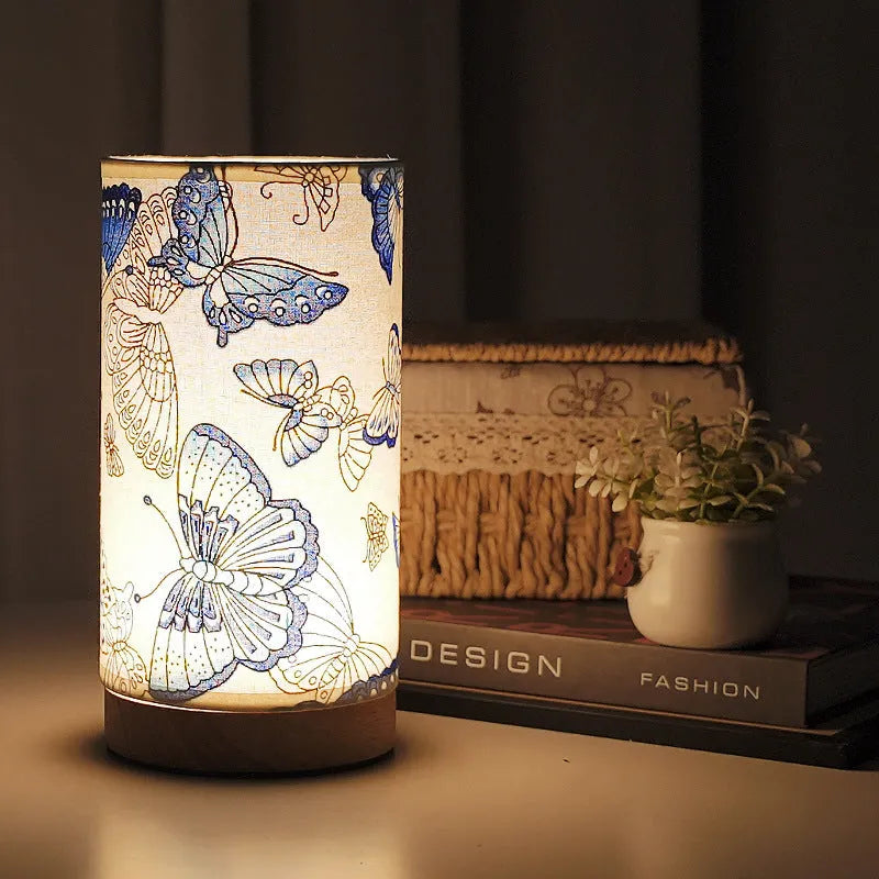 Creative USB table lamp with fabric shade in blue butterfly pattern on modern desk