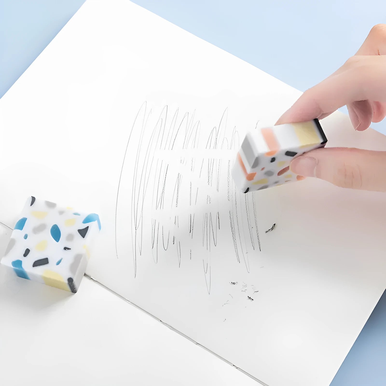 Small white PVC eraser for art drawing on a blue background.