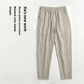 Man wearing beige striped cropped casual cotton-linen trousers on a summer day.
