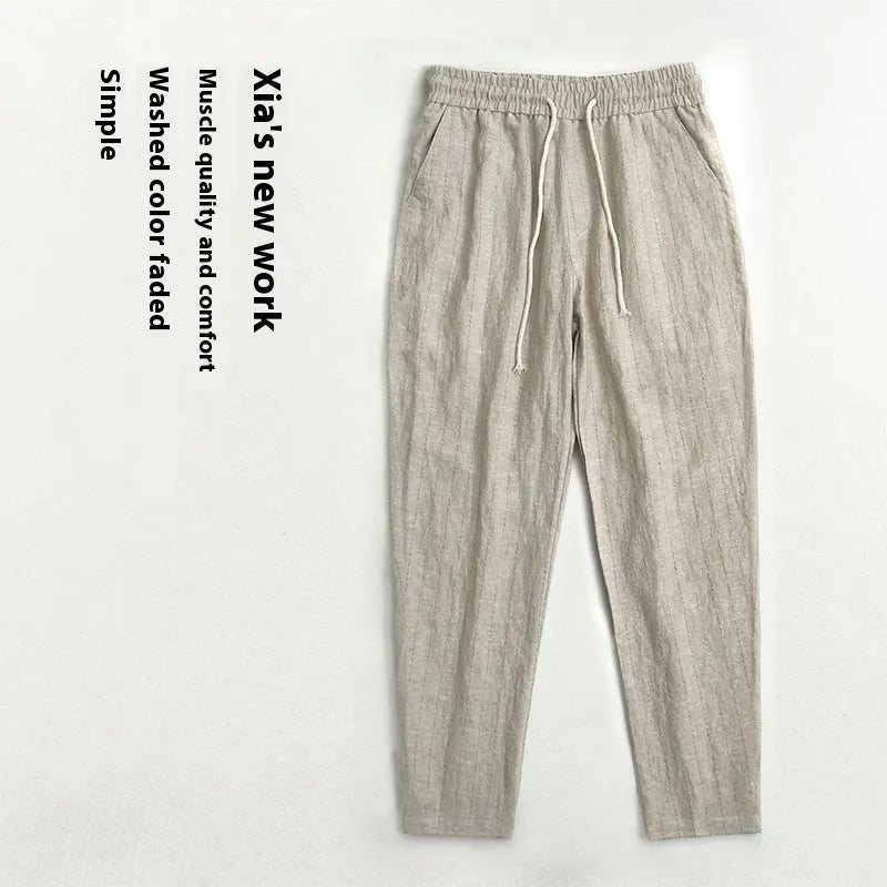 Man wearing beige striped cropped casual cotton-linen trousers on a summer day.