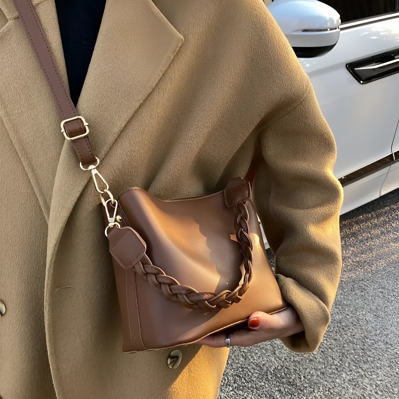 Khaki coloured PU leather one-shoulder crossbody bucket bag with woven detail on the front.
