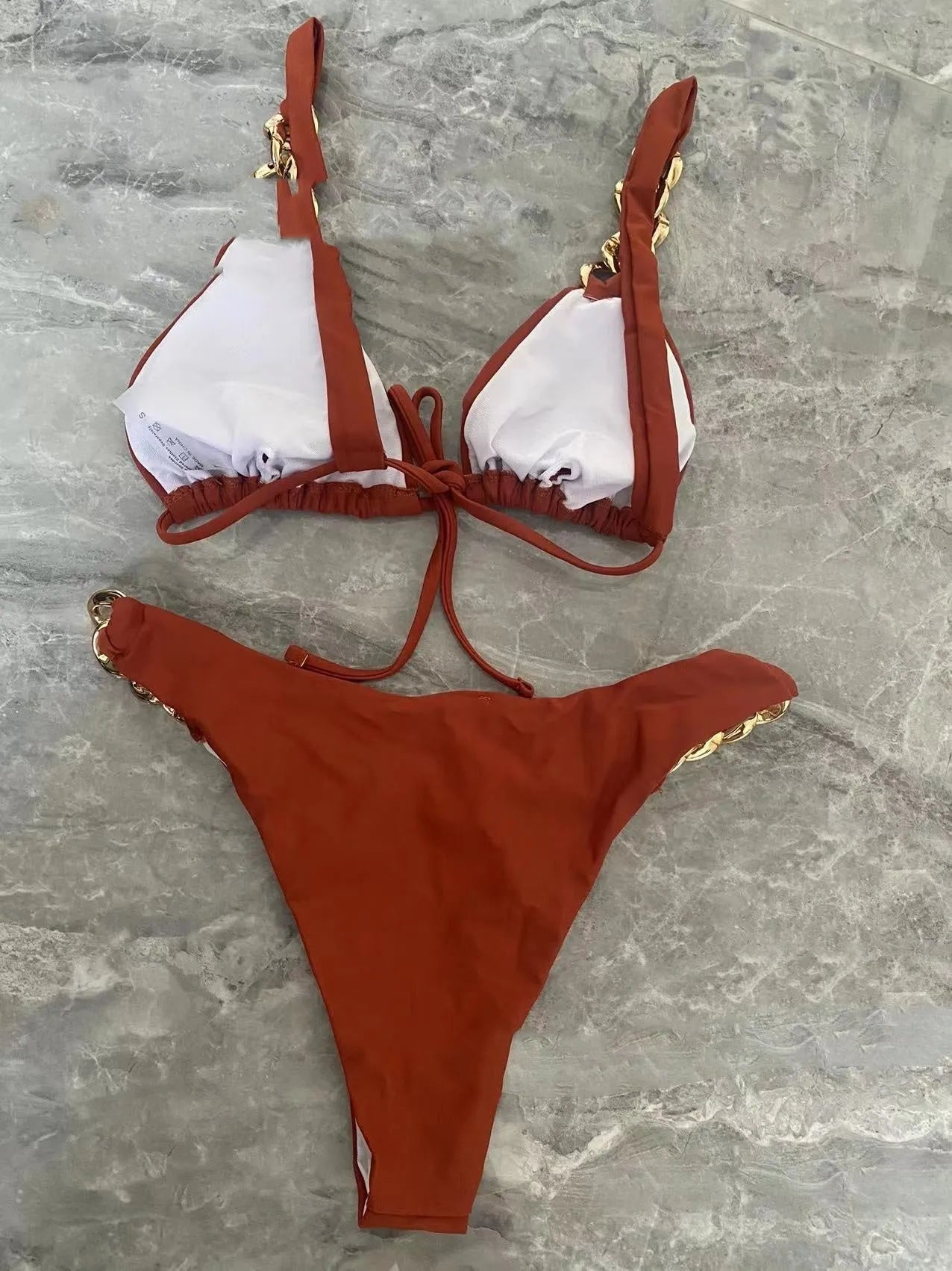Brown women's tube-top push-up bikini with ring tether detailing on a solid background.