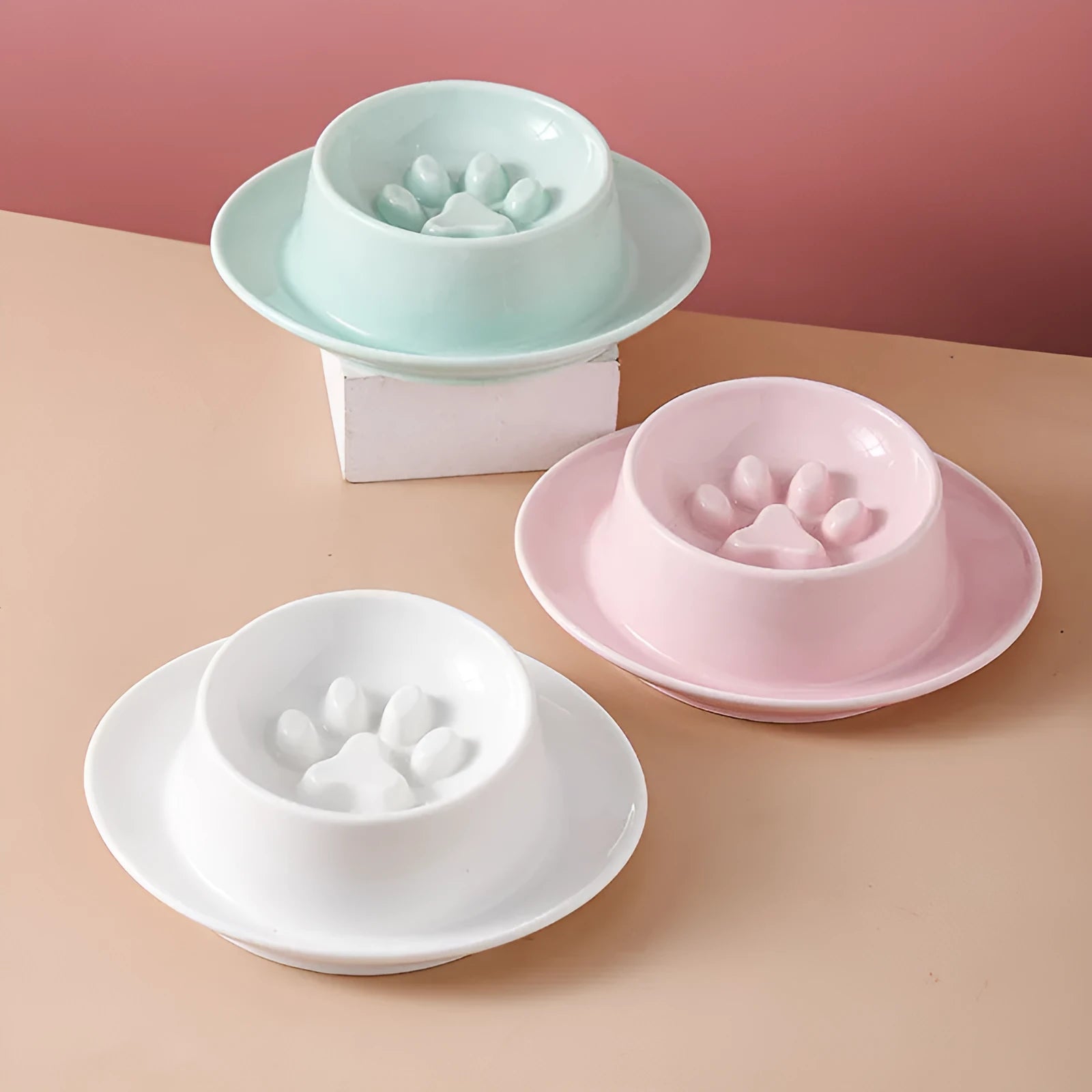 Green ceramic slow feeder pet bowl with central anti-choking basin on a white background.
