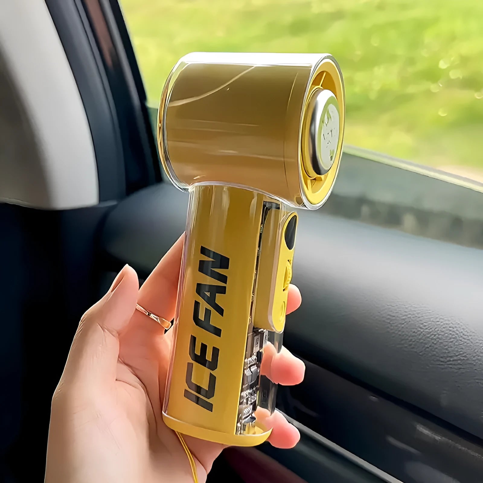Small yellow handheld fan with refrigeration ice compress function on a table