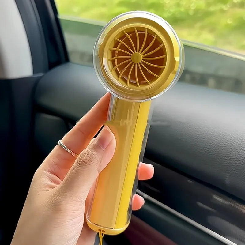 Small yellow handheld fan with refrigeration ice compress function on a table