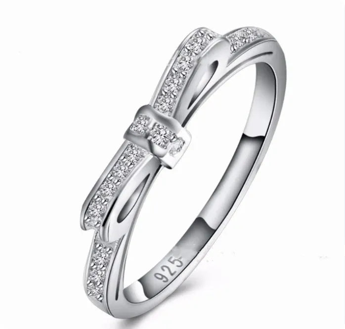 Silver-coloured fashion ring with a bow design adorned with clear zircon crystal stones.