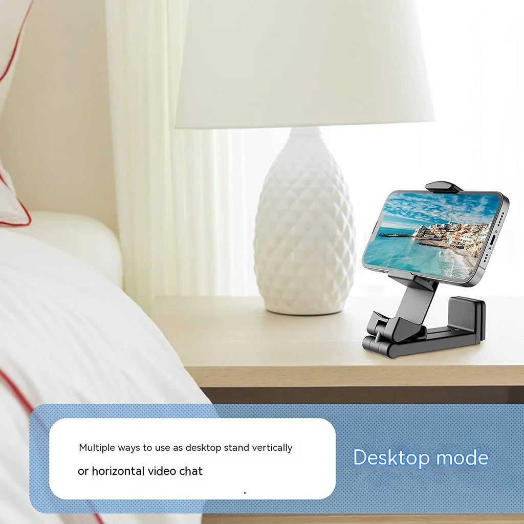 Black foldable rotating universal phone holder shown open on a desk, holding a smartphone.