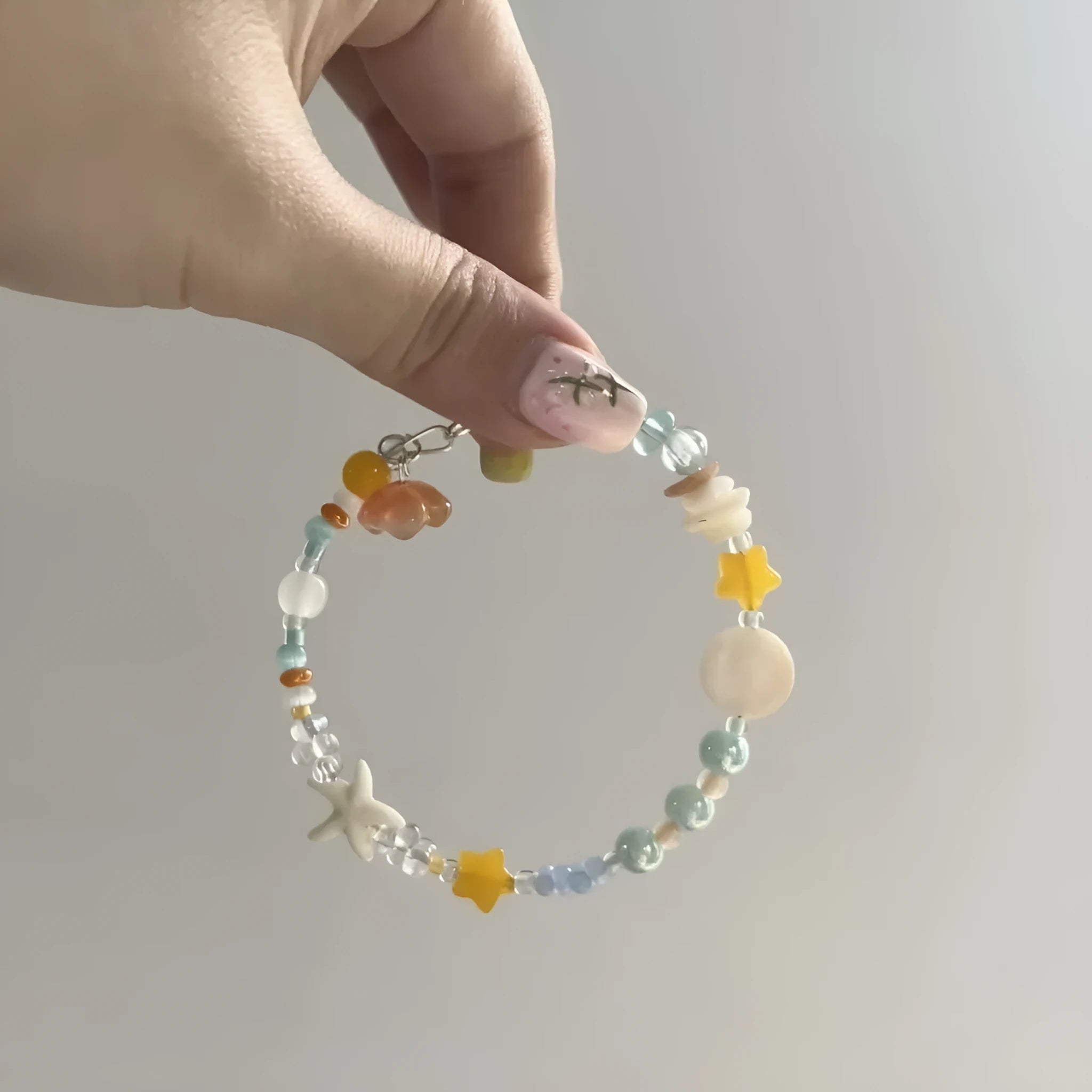 Orange women's bracelet with diamond links and round decorative elements on wrist