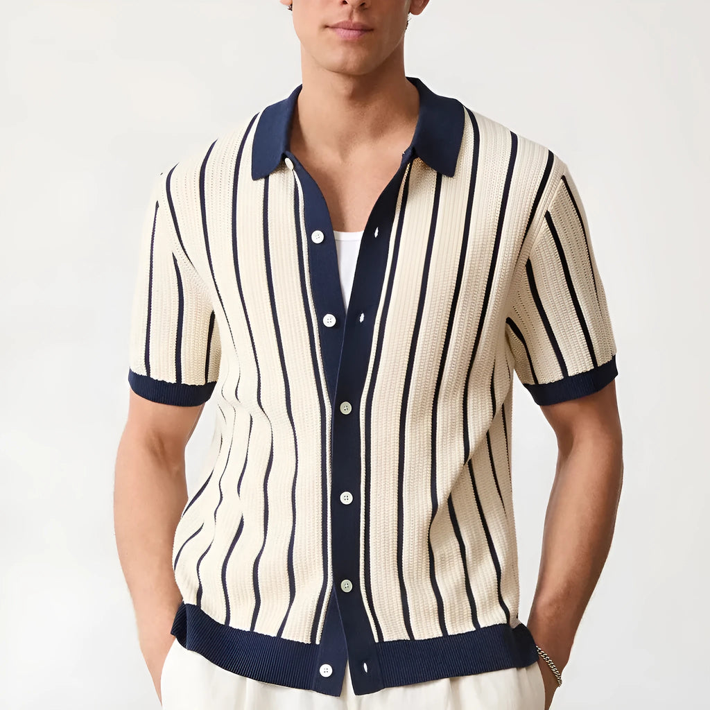 Man wearing a white asymmetric lapel knitted polo shirt with a striped pattern.