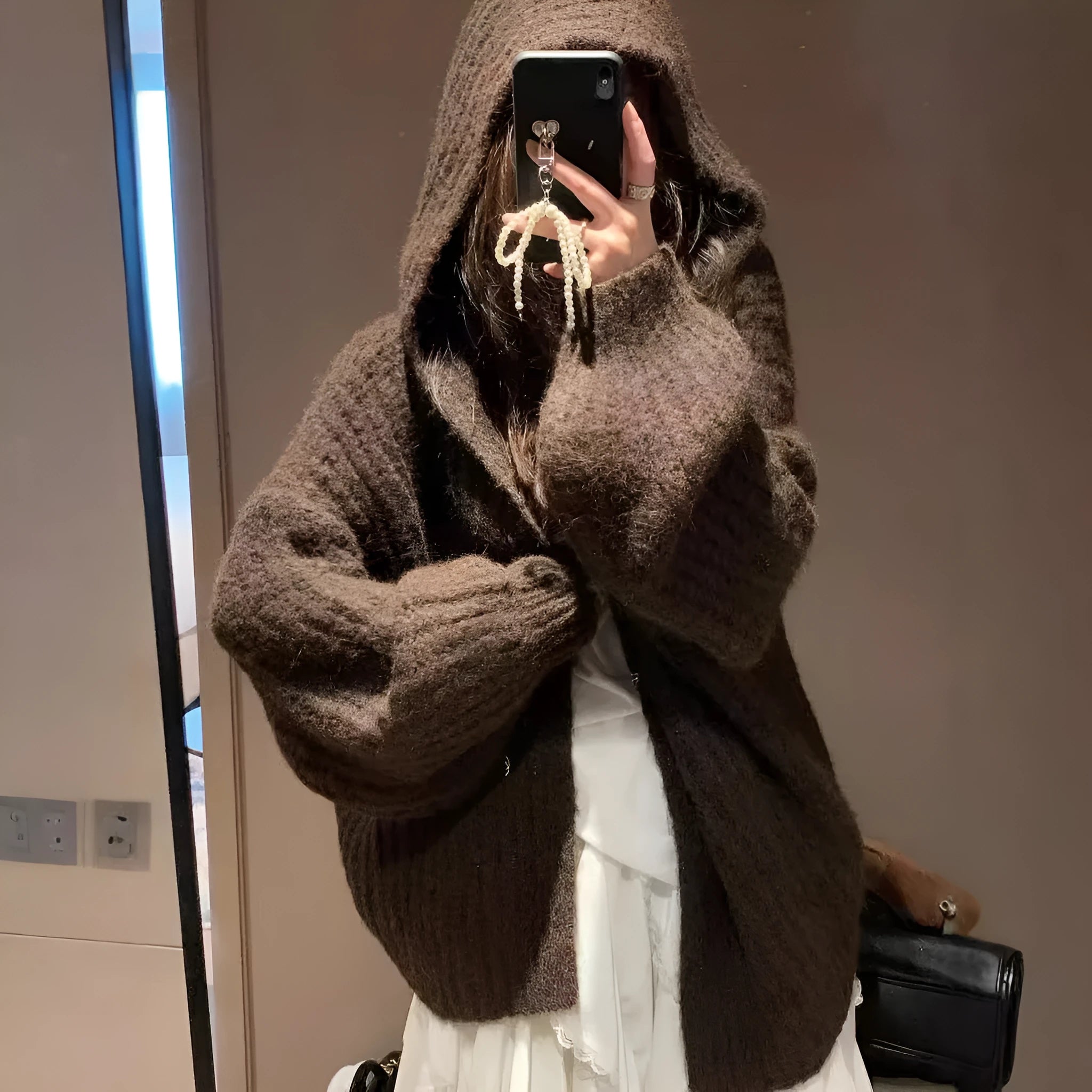Brown women's hooded sweater cardigan with thick knit and loose fit on a hanger.