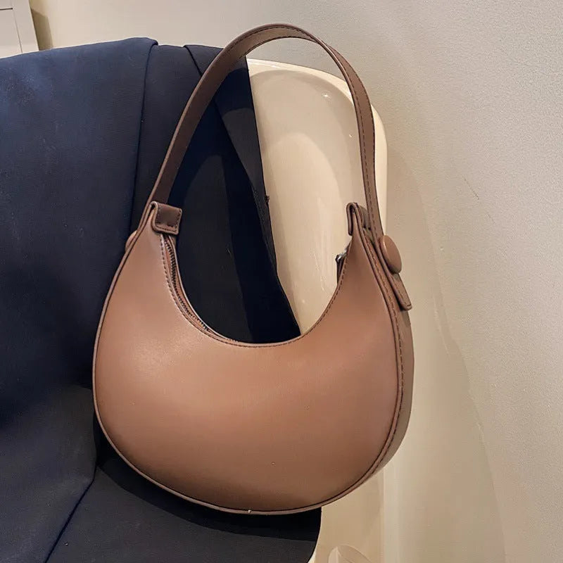 Women's retro dumpling-shaped shoulder bag in PU leather showing internal zipper pocket.