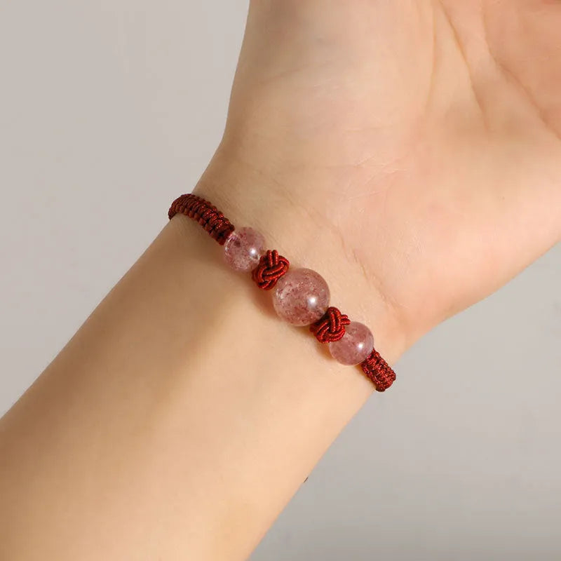 Woven red rope bracelet with alloy beads and natural strawberry quartz or obsidian stone beads