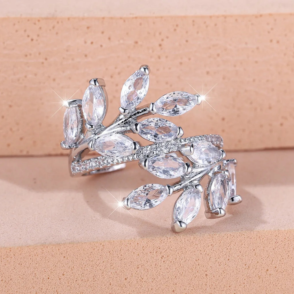 Copper leaf-shaped ring with horse eye design and zircon stones on a finger, showing adjustable opening.