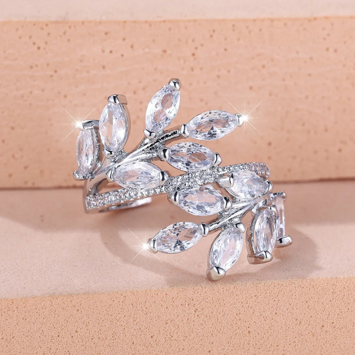 Copper leaf-shaped ring with horse eye design and zircon stones on a finger, showing adjustable opening.