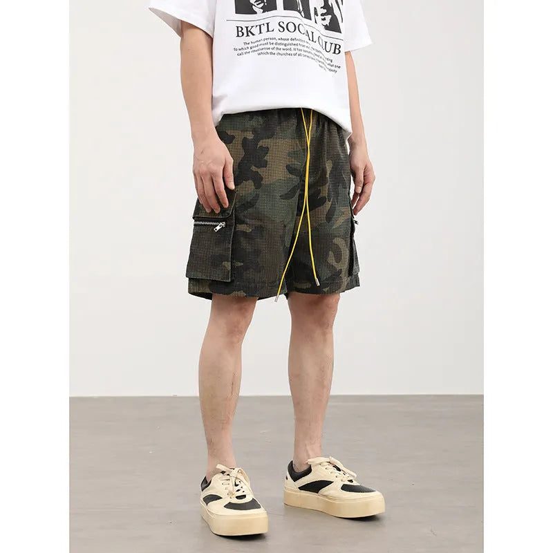 Men's camouflage cotton blend cargo shorts with multiple pockets, shown in a loose cropped fit.