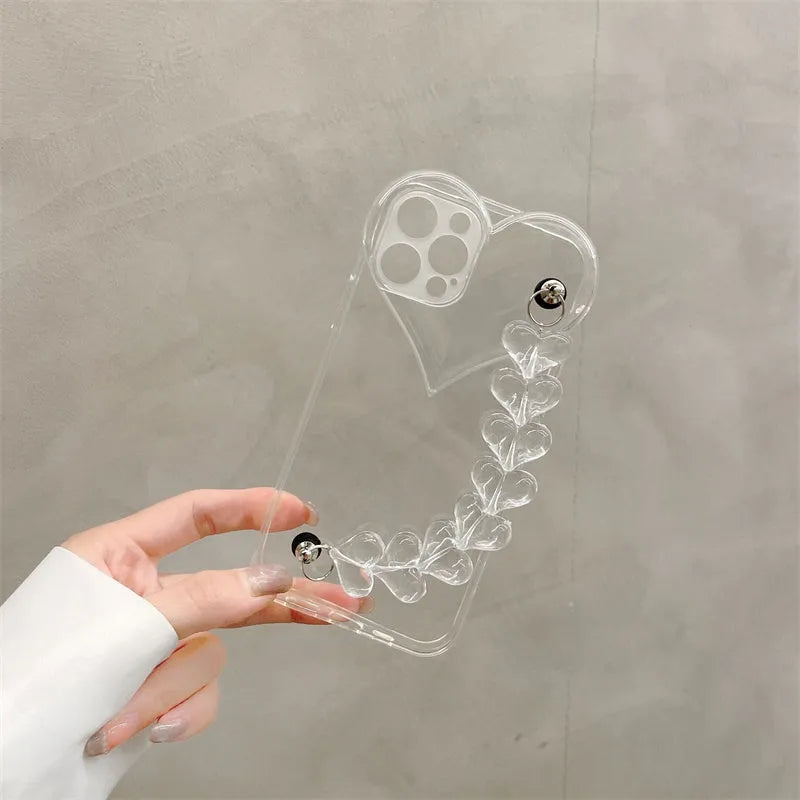 Transparent iPhone case with an attached clear love heart charm bracelet on a TPU shell.