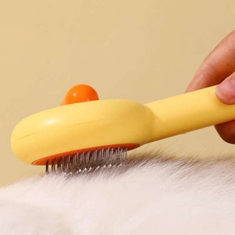 Small yellow duck-shaped pet grooming comb with needle pins for cats and dogs