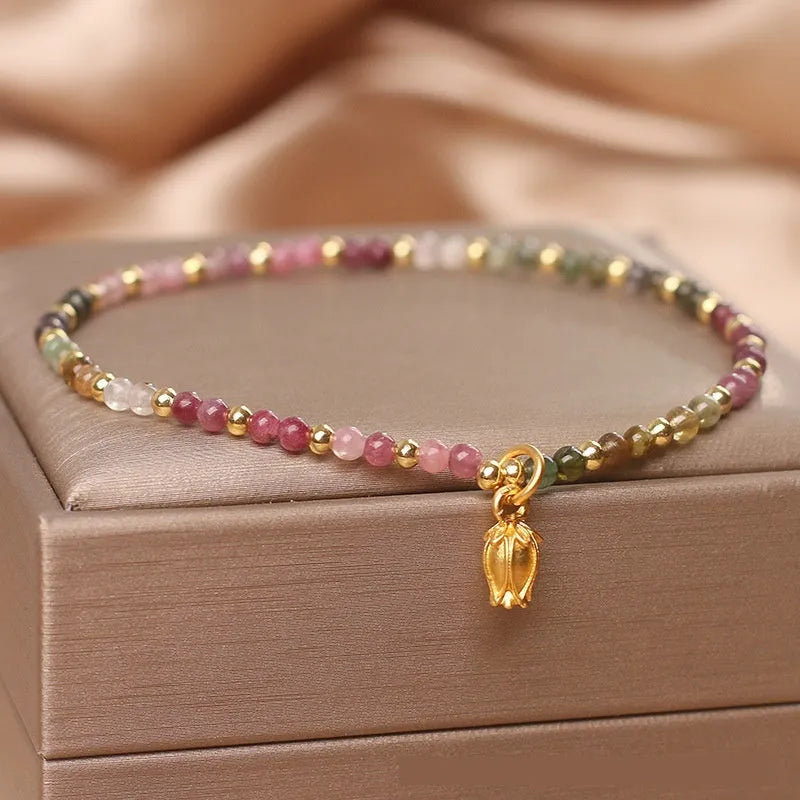 Natural tourmaline beaded floral anklet shown as adjustable bracelet on woman's wrist