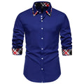 Man wearing a blue plaid long sleeve shirt with a white triangle contrast collar.