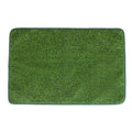 Green washable dog grass pee mat with realistic lawn texture on a patio.