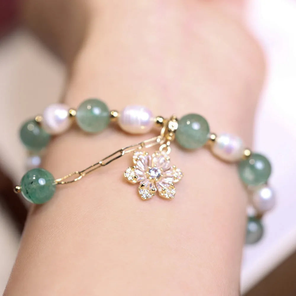 Green geometric strawberry freshwater pearl bracelet with small flower charm and Chinese knot design.