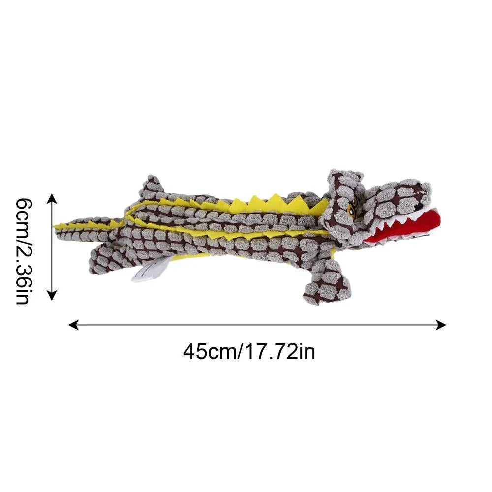 Blue plush crocodile-shaped dog toy with corduroy texture and squeaker, shown next to measuring tape