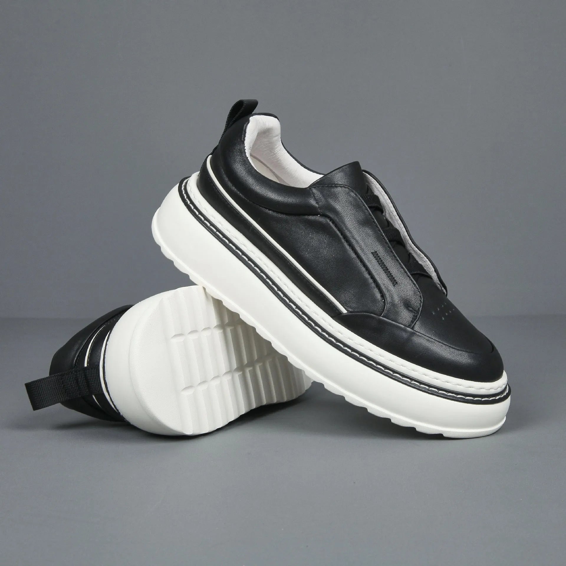 Breathable casual slip-on sneaker in black with first layer cowhide upper, platform mid heel, and sewing thread detail