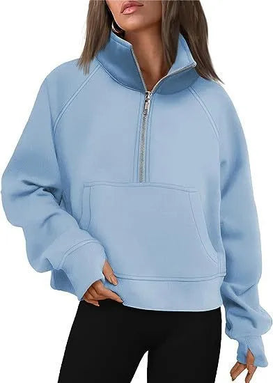 A woman wearing a loose-fitting apricot-coloured fleece-lined sweater with a lapel neckline and raglan sleeves.