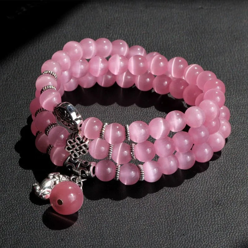 Women's opal bracelet with a Cat Eye charm, shown in one of six colours, wound three times around a wrist.