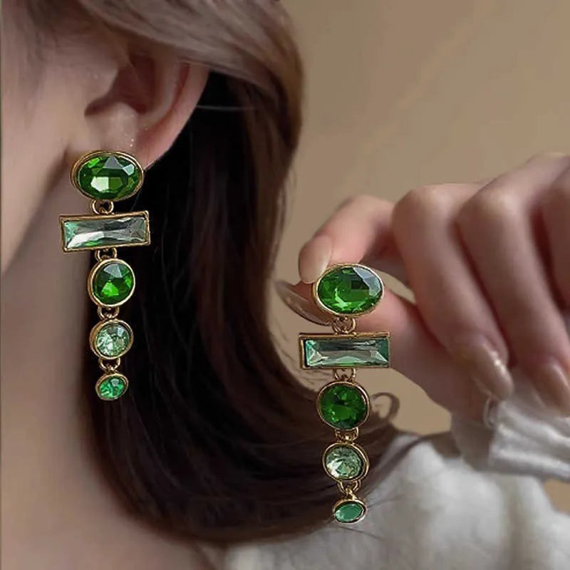 A pair of green gradient retro earrings with a geometric shape, tassel detail, and zircon inlay on an alloy base.
