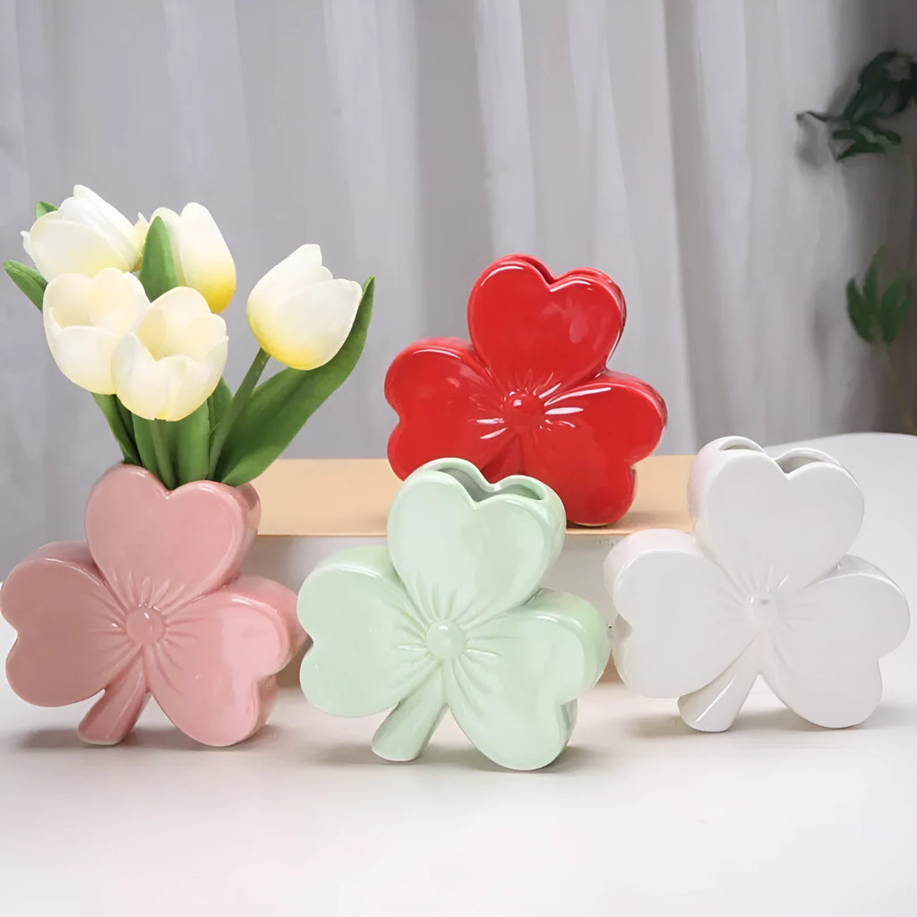 White porcelain clover-shaped ceramic vase in European style, on a desktop.