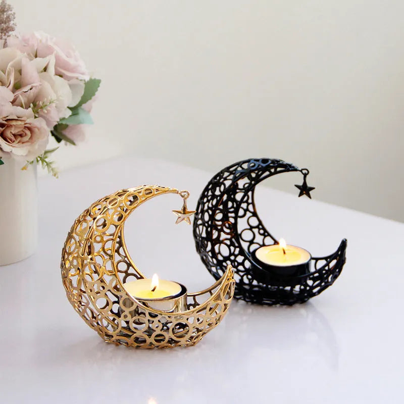 Gold metal crescent moon candle holder with hollow design on a dark surface