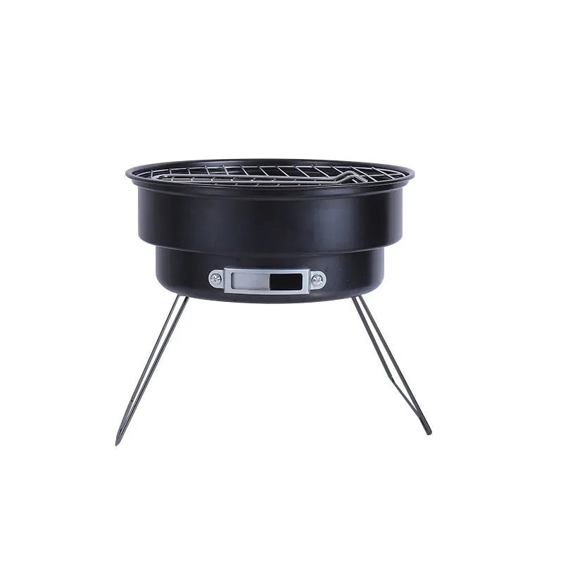 Small, round, folding metal ice stove grill with mesh top and legs, set up for outdoor use.