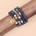 Blue patterned stone bead multi layer alloy bracelet with clasp on a white background.