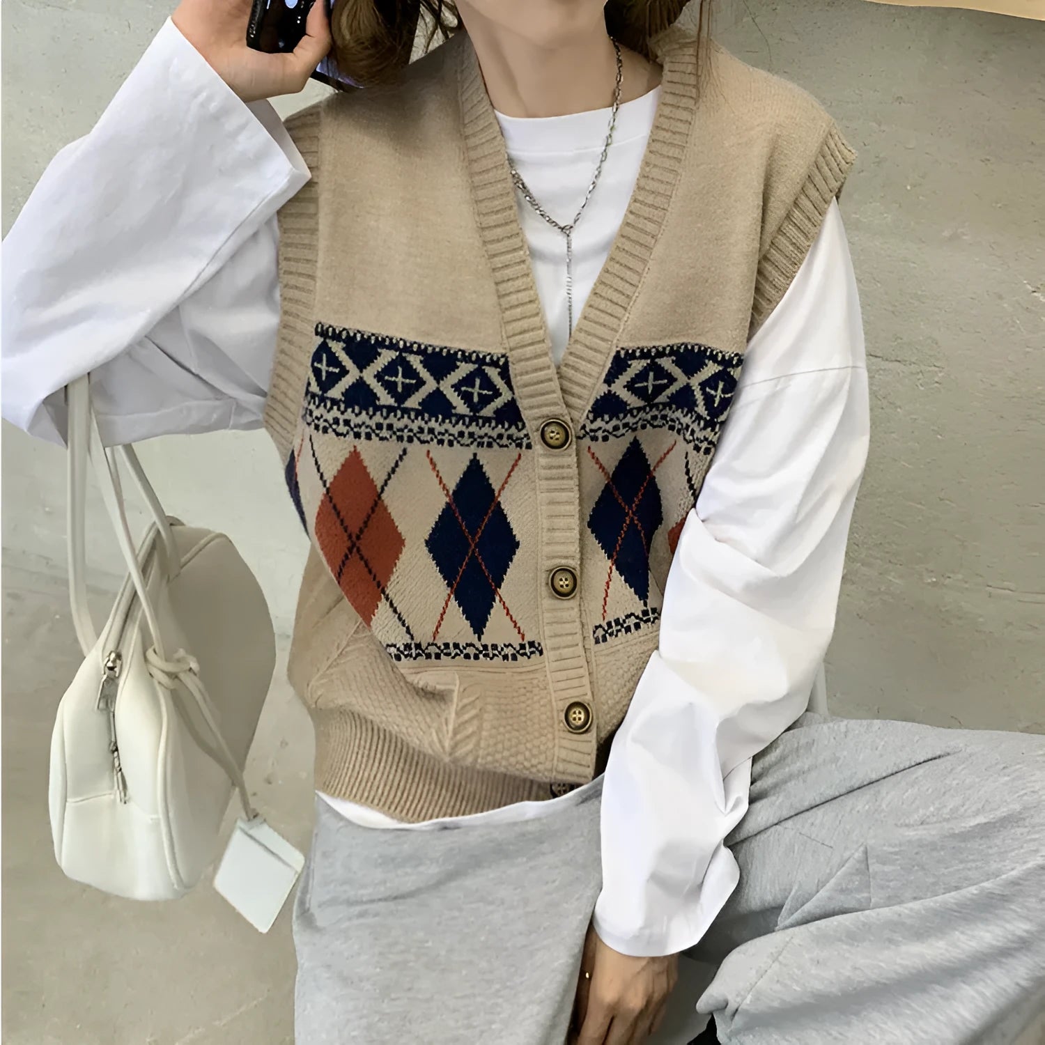 Loose-fit women's sleeveless cardigan top in a diamond plaid pattern, shown in khaki colour.