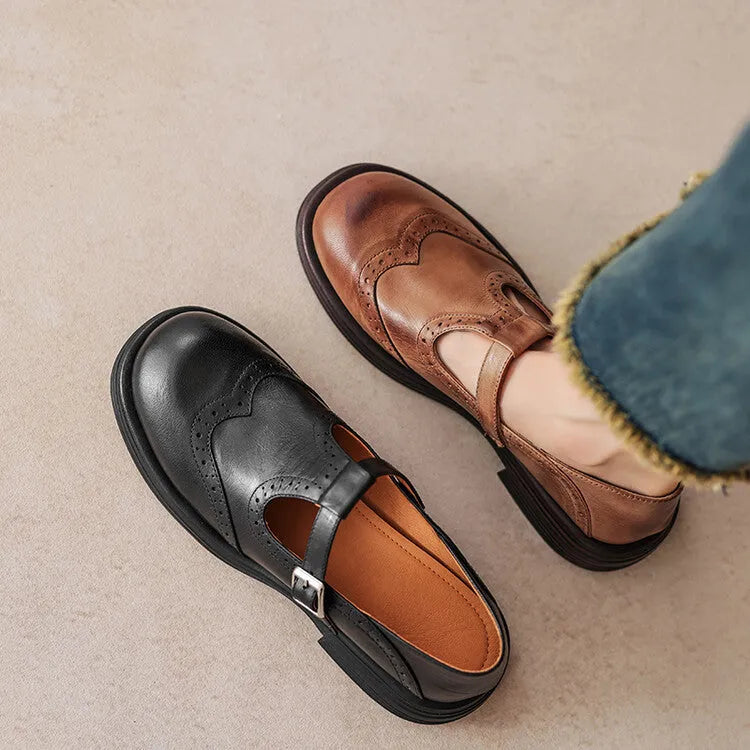 Women's black British style leather flat shoe with round toe and slip-on design on a neutral background.