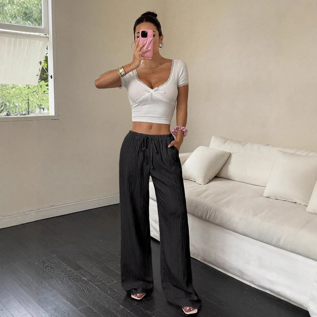 Black wide-leg women's trousers with a lace-up detail on the mid-rise waistband.
