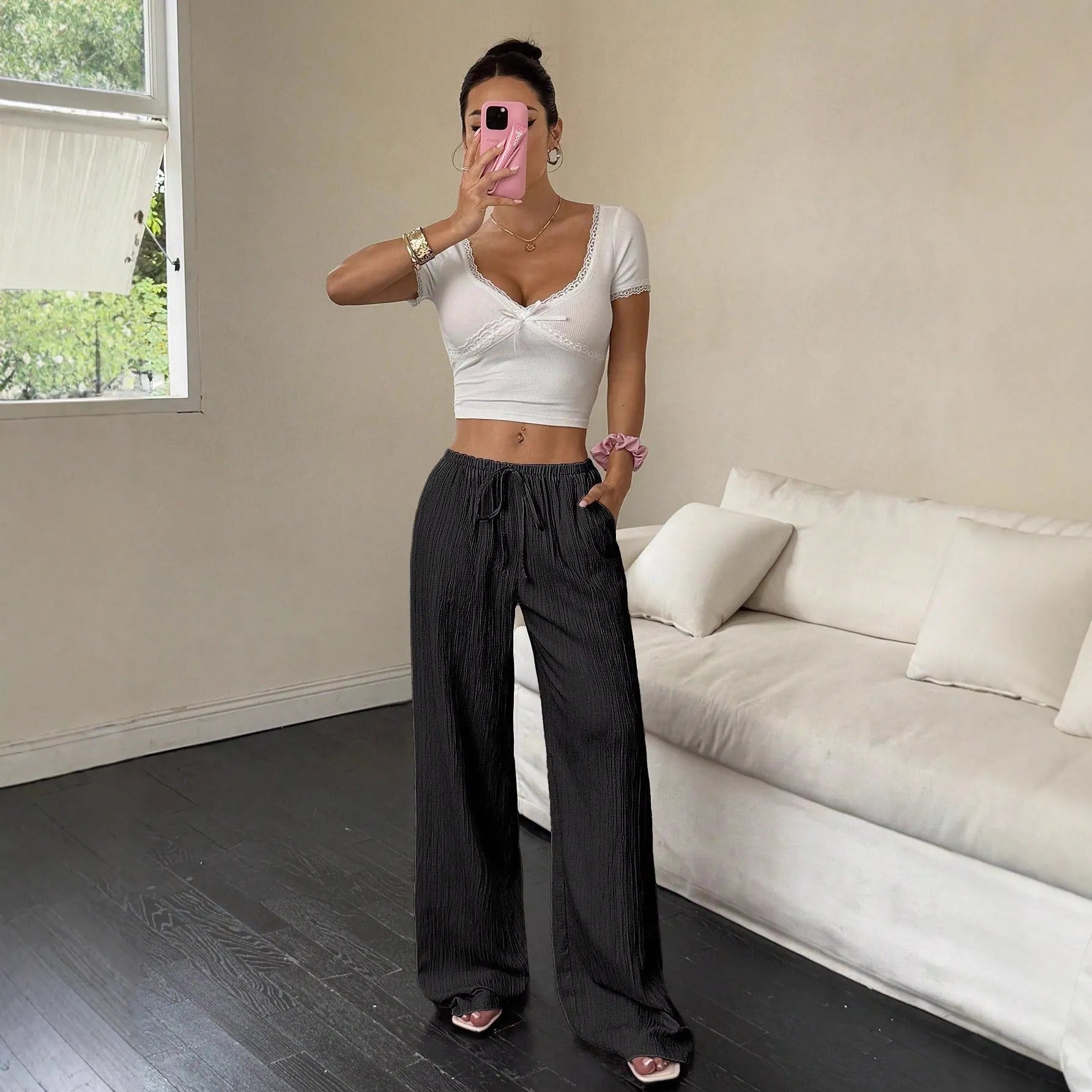 Black wide-leg women's trousers with a lace-up detail on the mid-rise waistband.