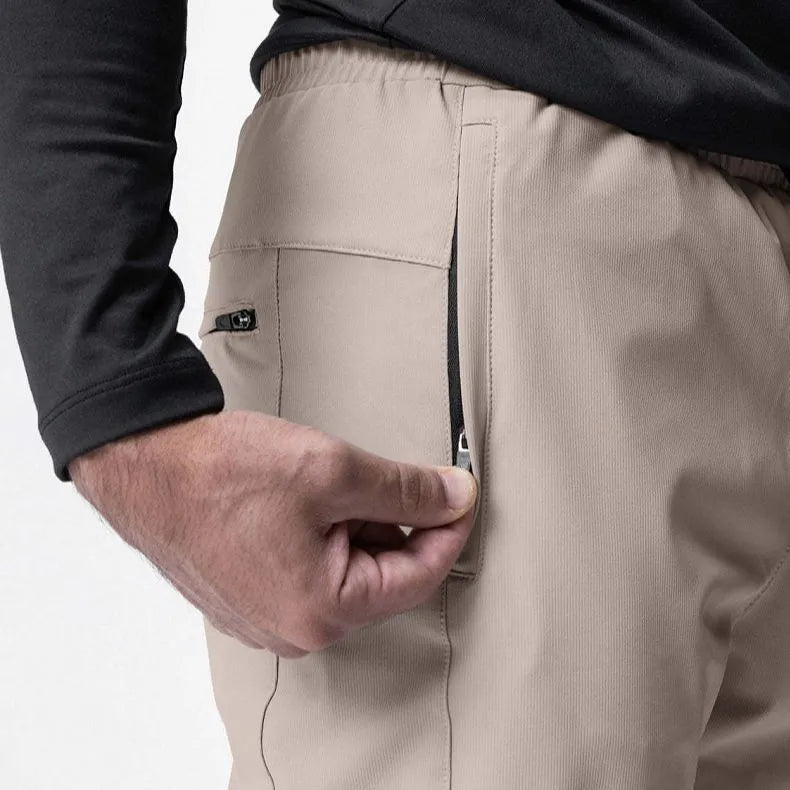 Man wearing dark grey loose-fit ankle-tied fitness trousers made of quick-drying polyester.