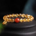 Natural red agate and gold ruby bead bracelet on a wrist, showing polished stones.