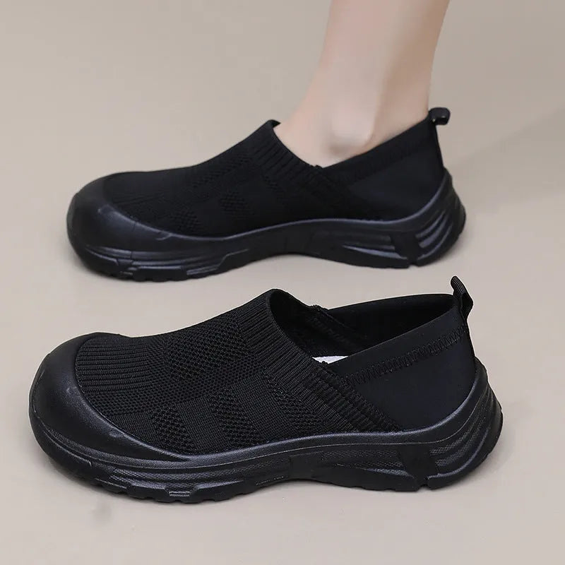 Women's black slip-on casual shoes with round toe and flat PVC sole.