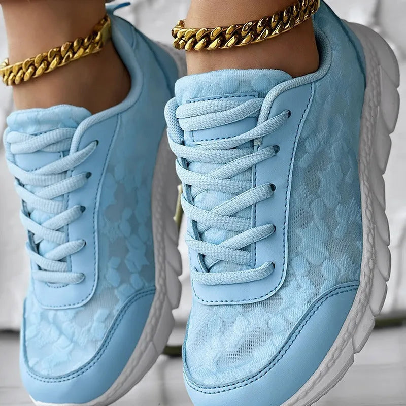 Women's white canvas running shoes with flat heel and round toe on a plain background.