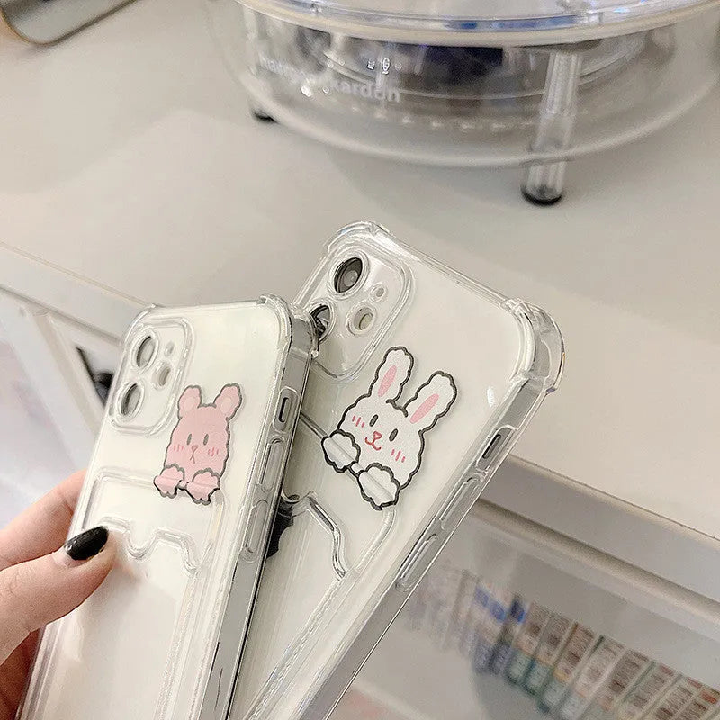 Transparent cartoon card holder phone case for Apple iPhone on a table.