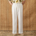 Woman wearing loose-fit linen trousers with a high elasticated waist in a straight-leg cut.
