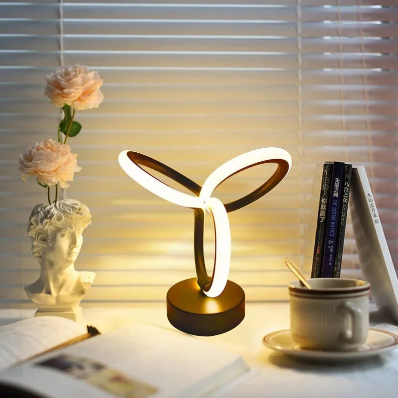 Black musical note shaped Bluetooth LED night light with remote control on a bedside table.